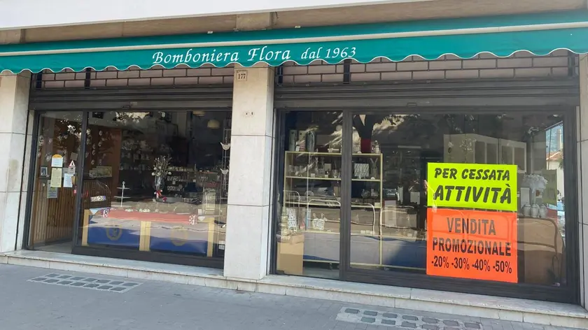 Il negozio di via Cavour con i cartelli che annunciano la chiusura