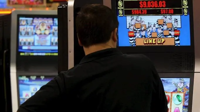 Un uomo gioca con una slot machine in una foto d'archivio. ANSA / YM YIK .