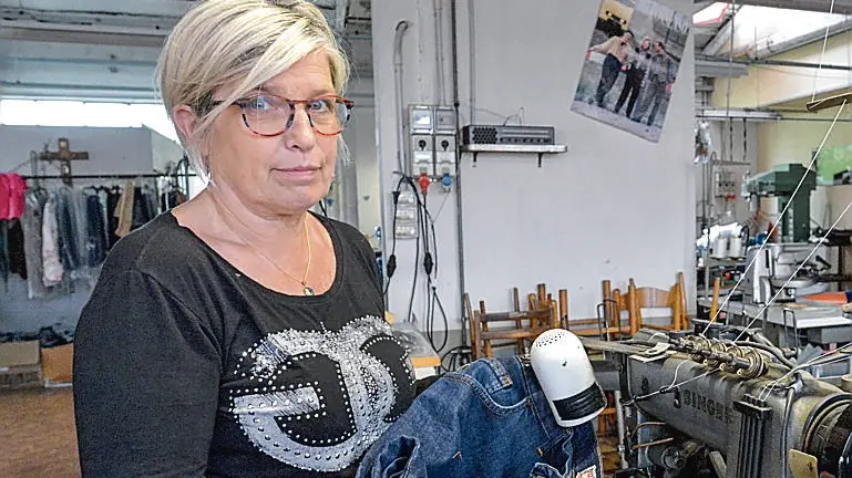 Tiziana Pullini davanti a telai e macchine da cucire