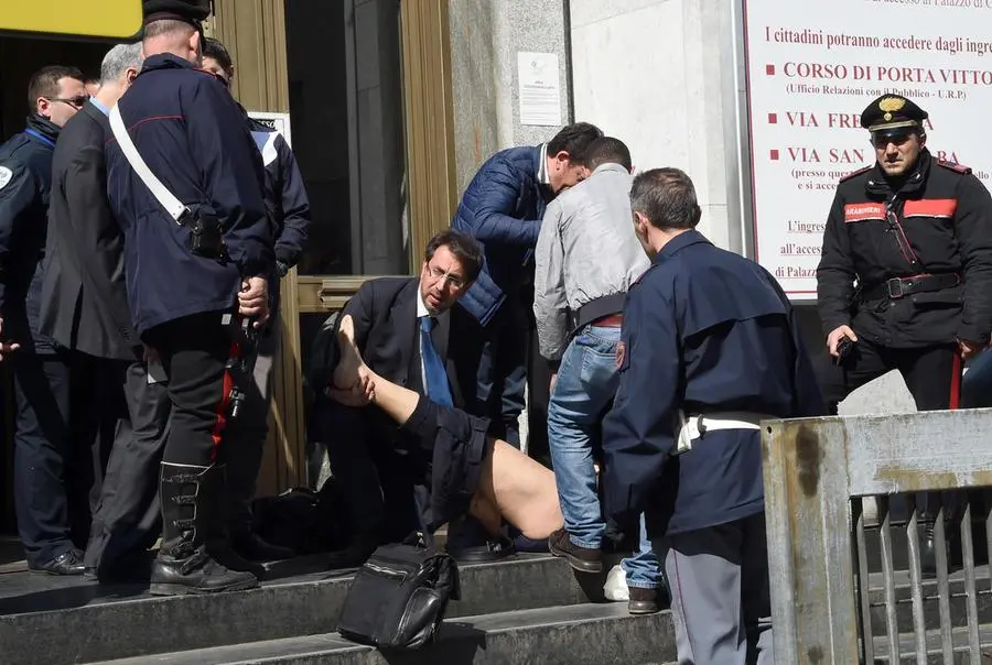 Una persona soccorsa all'esterno di Palazzo di Giustzia a Milano, 9 marzo 2015. ANSA/DANIEL DAL ZENNARO