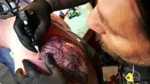 Un tatuatore all’opera su un cliente