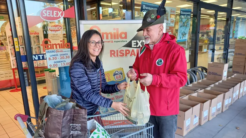 Un volontario del Banco alimentare riceve una borsa per i poveri